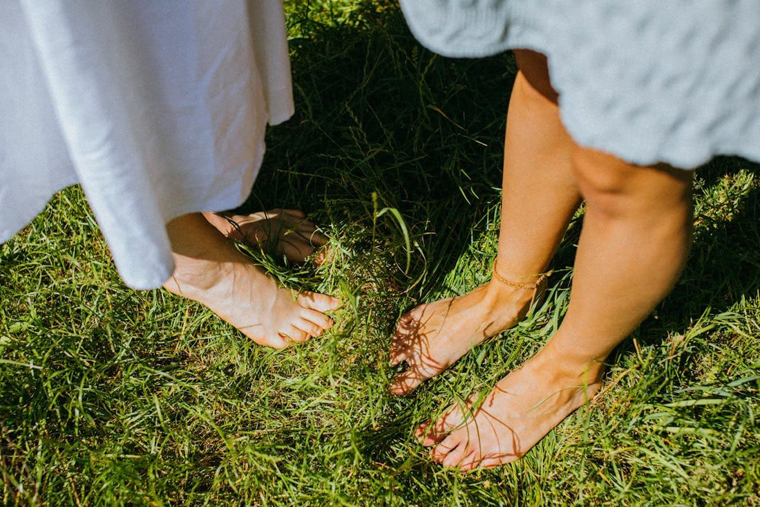 How Grounding Supercharges Your Biostack For Better Energy, Sleep, And Recovery with bare feet on grass.
