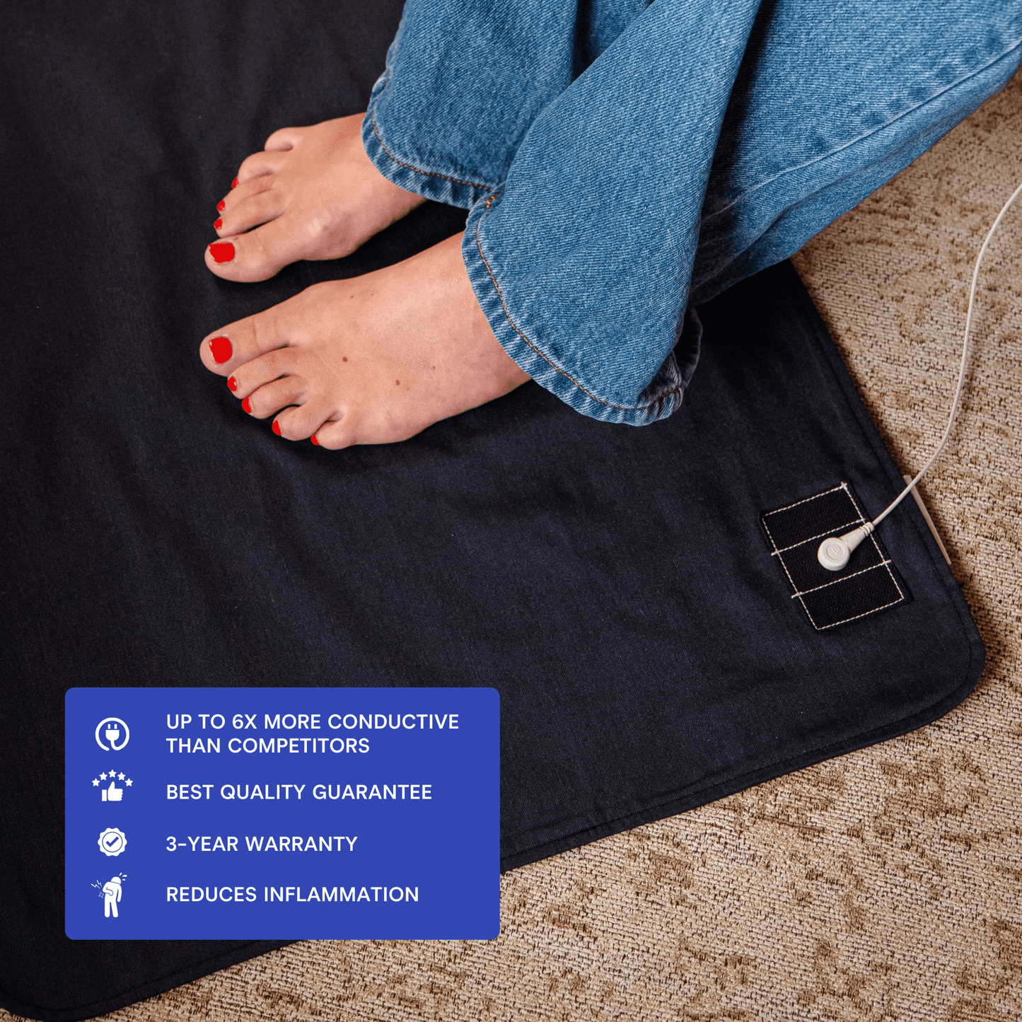 Bare feet resting on a stainless steel earthing mat under a desk
