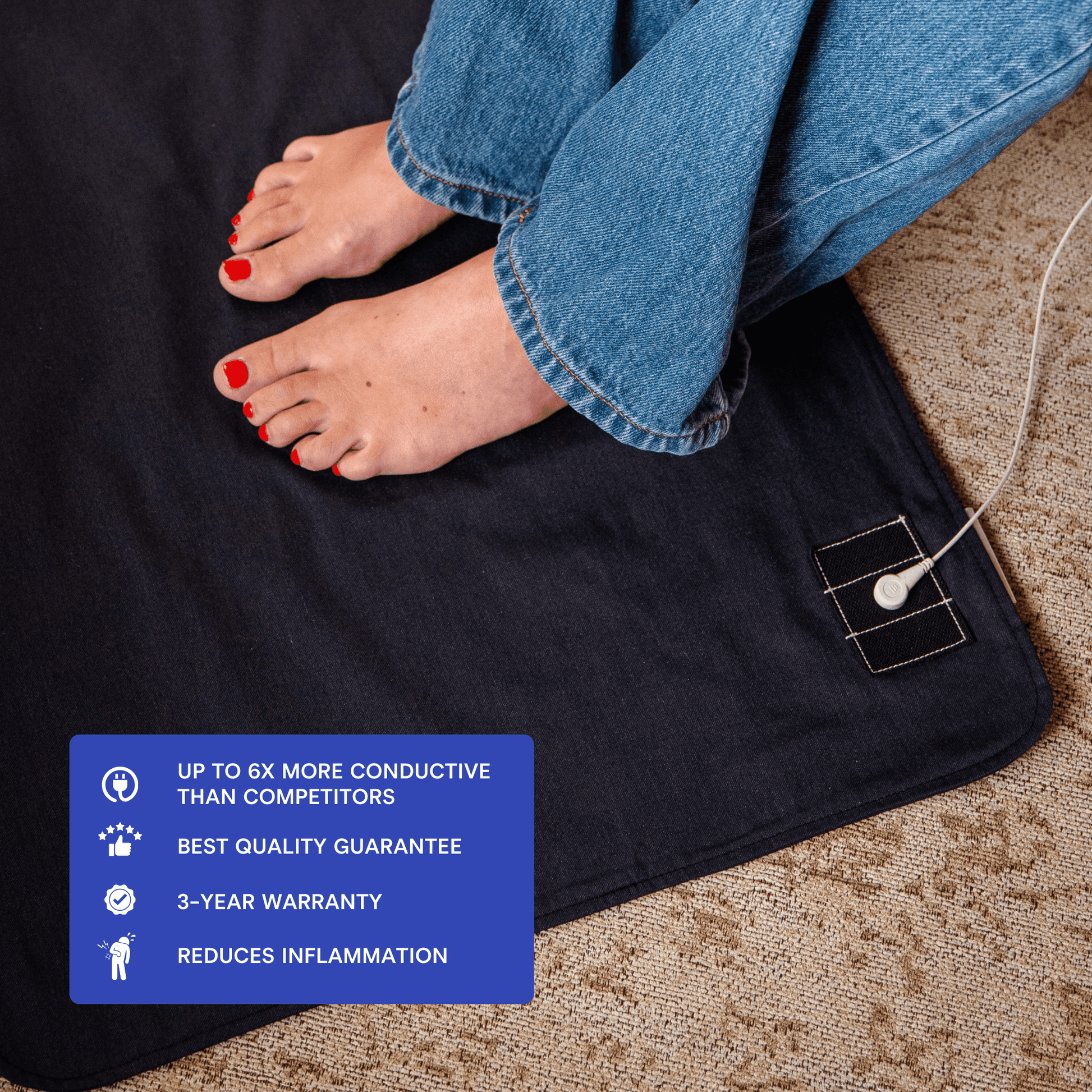 Bare feet resting on a stainless steel earthing mat under a desk