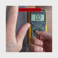 hand touching grounding sheet and reducing voltage with multimeter