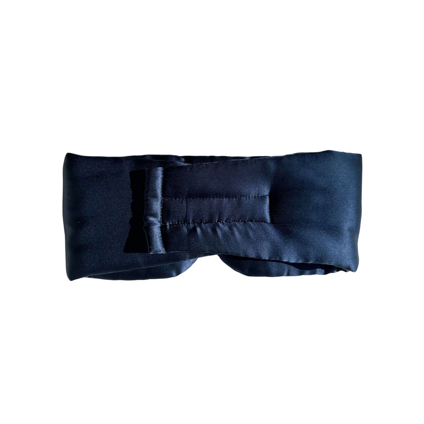 Silk sleep mask displayed on soft pillow in bedroom setting